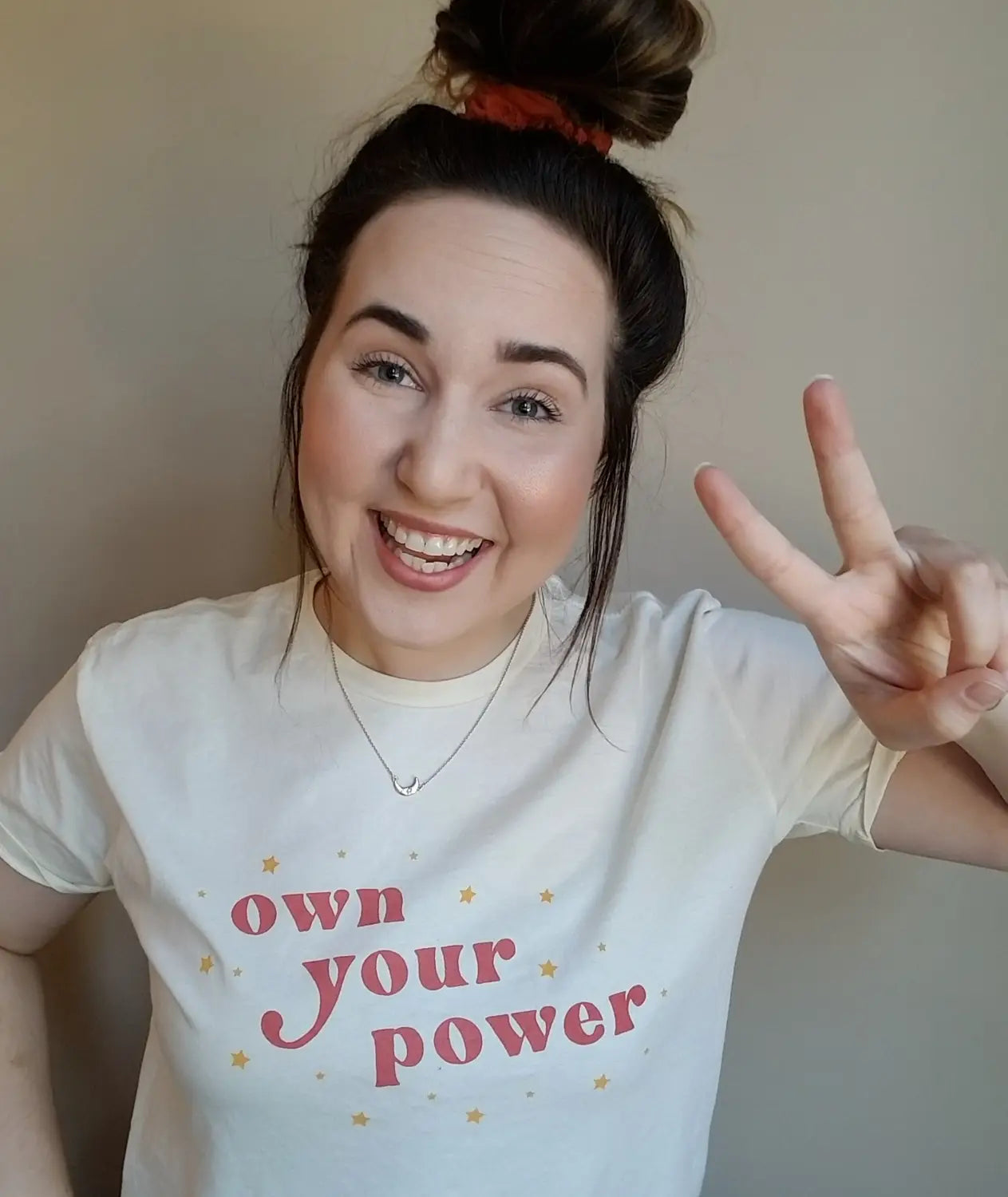 White t-shirt with own your power text in pink by Jennae Cecelia, best-selling author.