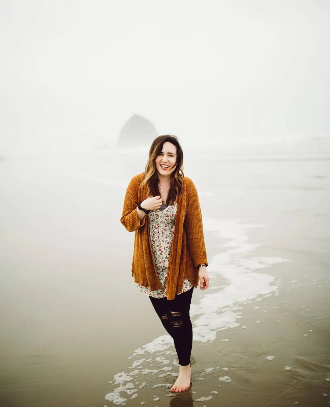 Woman in rust cardigan and floral dress enjoying shallow water during Instagram Live with Jennae Cecelia