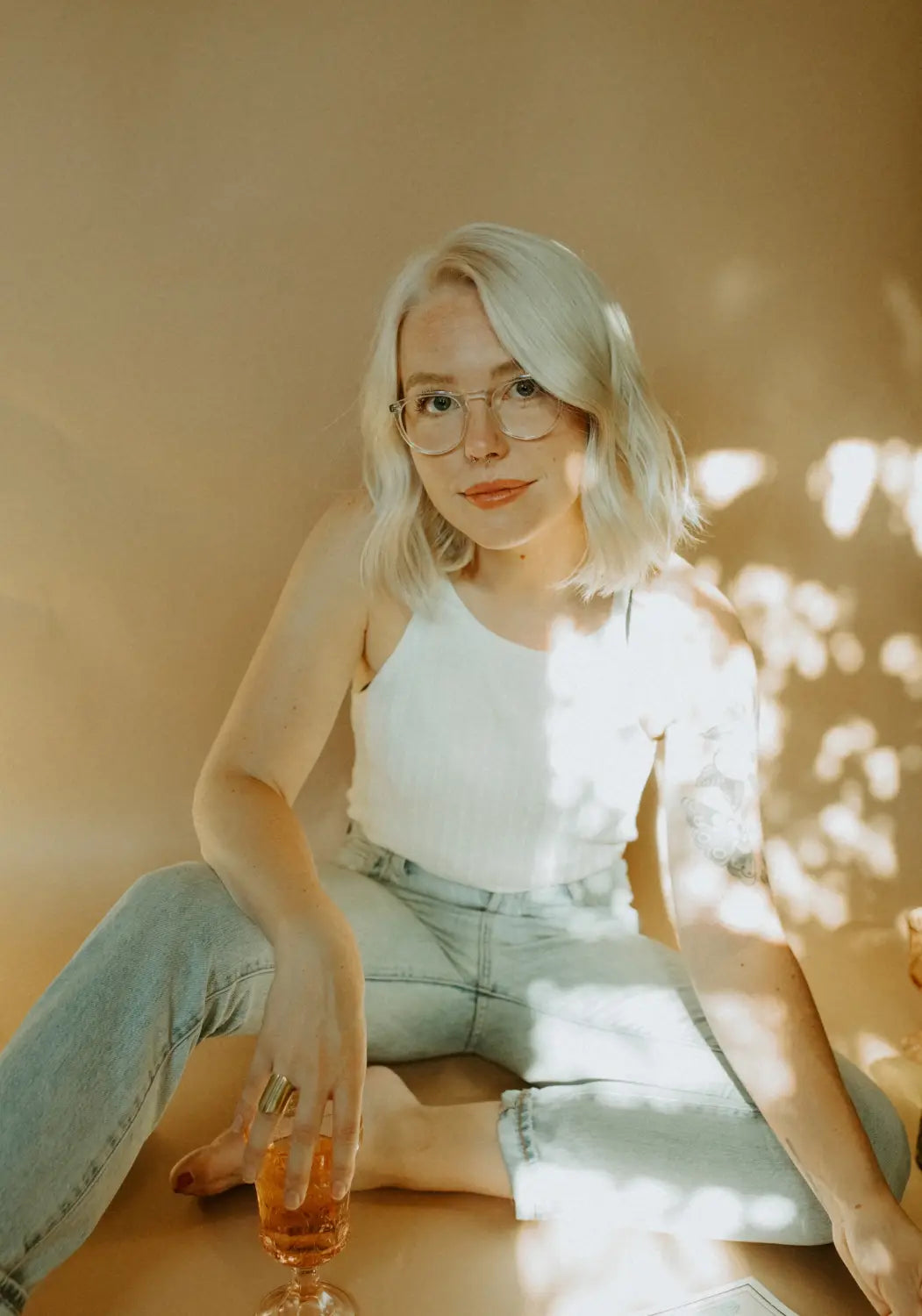 Sydney Michuda, super creative freelance designer, sitting casually with a drink.