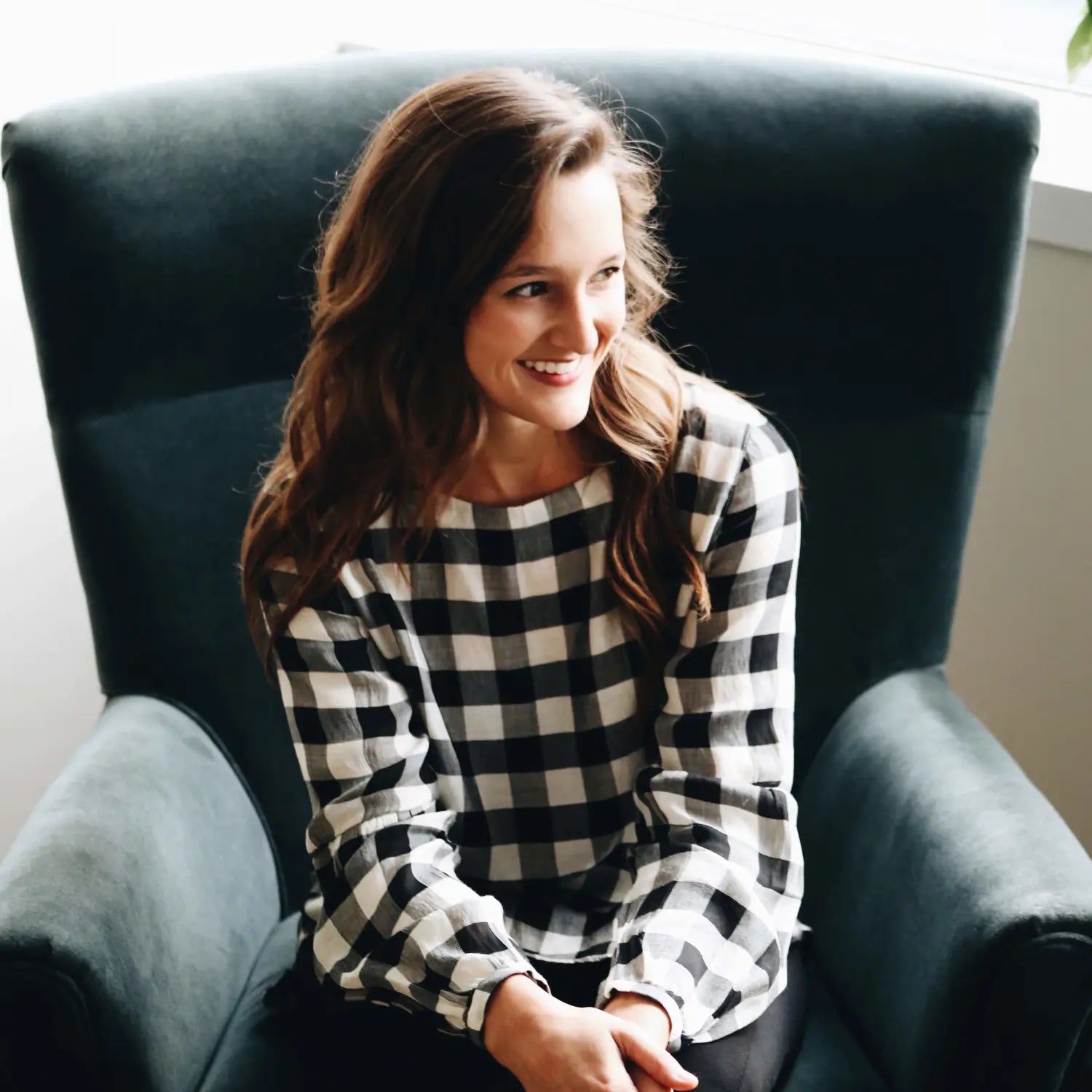 Olivia Herrick in a checkered sweater, showcasing her glass-half-full approach.