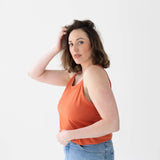 Person in coral tank and high-waisted jeans from Core Basics Mom Crop collection.