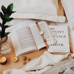 Open book with a leather watch strap, featuring Author Brianna Wiest’s global bestseller