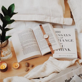 Open book with a leather watch strap, featuring Author Brianna Wiest’s global bestseller