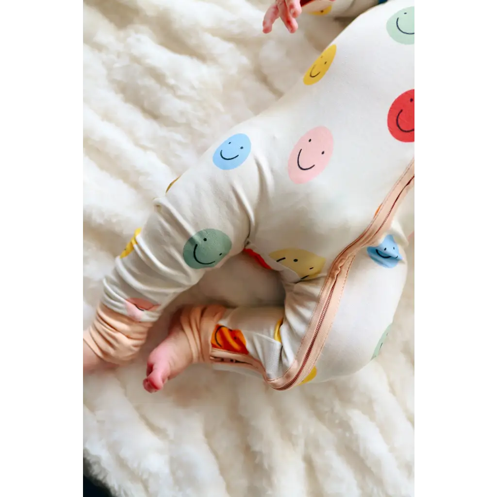 Baby pajamas with colorful smiling faces, perfect for cozy nights in the Smiles Bamboo Baby Sleeper