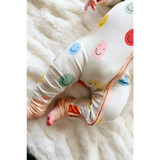 Baby pajamas with colorful smiling faces, perfect for cozy nights in the Smiles Bamboo Baby Sleeper
