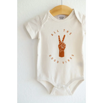 White Good Vibes Organic Cotton Baby Onesie with peace sign graphic in brown