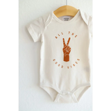 White Good Vibes Organic Cotton Baby Onesie with peace sign graphic in brown
