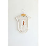 White baby onesie in organic cotton with brown peace sign graphic for good vibes organic style