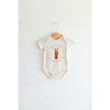 White baby onesie in organic cotton with brown peace sign graphic for good vibes organic style