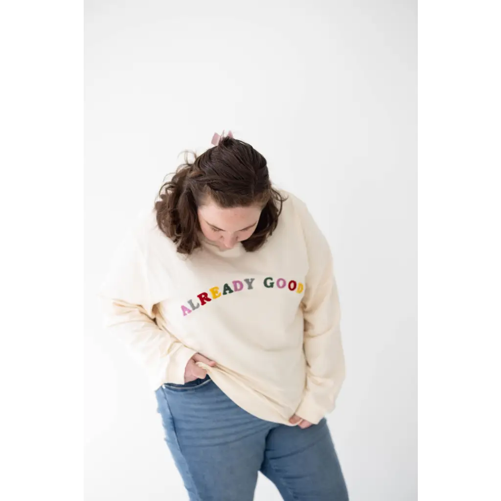 Cream-colored sweatshirt with vibrant ALREADY GOOD text in organic cotton style