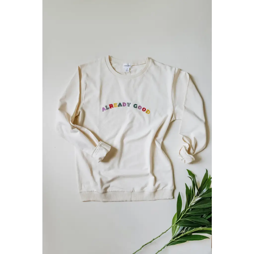 White sweatshirt made of organic cotton with colorful good embroidered text on front