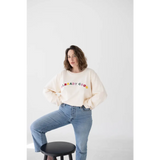 Cream-colored sweatshirt featuring colorful BRADY CREW text made from good embroidered organic cotton