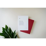 White paper with poetry next to a red notebook and green leaf, free shipping featuring art
