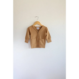 Tan Buttery Soft Baby Grandpa Cardigan sweater hanging on a wooden hanger for holiday season