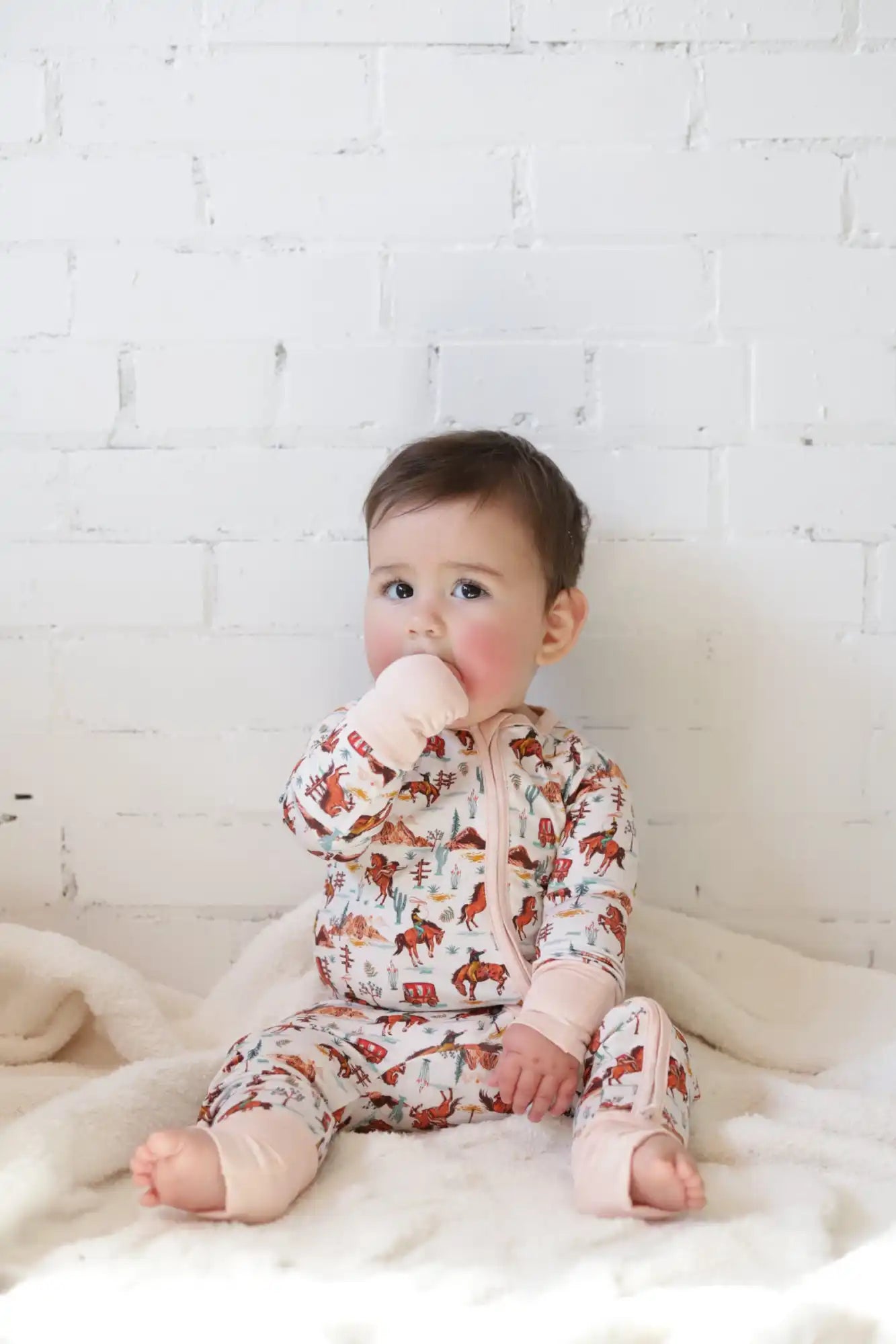 Baby onesie with reindeer pattern, pink and white material.