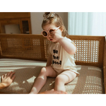 Toddler in pink sunglasses on bench wearing Good Organic Cotton Baby Bodysuit