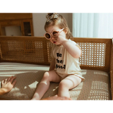 Toddler in pink sunglasses on bench wearing Good Organic Cotton Baby Bodysuit