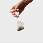 Hand holding heart-shaped tea bag from Big Heart Tea Co 10 Ct Tea Bags showroom