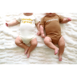 Two babies in coordinating Biscuits and Gravy and Meatball baby onesies in organic cotton
