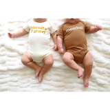 Two babies in coordinating Biscuits and Gravy and Meatball baby onesies in organic cotton