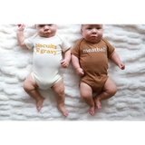 Two babies in adorable organic cotton gender neutral onesies featuring fun food themes