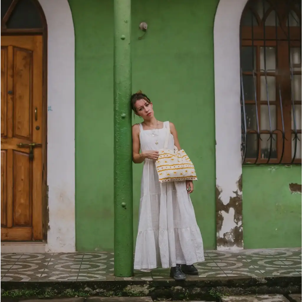 Woman in white dress with cosmic print tote kit showcasing block printing skills