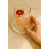 Pink bow glass with ice and orange slice, perfect for peace signs camp vibes