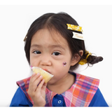 Child enjoying a cupcake in a plaid bib with Butter Noodles Hair Clips in her hair