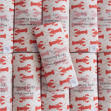 Rolls of wrapping paper with red lobster patterns for Navy Charlie Snap Bibs