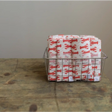 Wire basket with Navy Charlie Snap Bibs in Coral Lobster gift wrap for babies