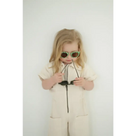 Child in beige jumpsuit rocking checkered baby kids sunnies for a cool style