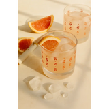 Two glasses of pinkish Cherries Cocktail with ice and grapefruit slices for peace signs camp