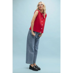 Woman in red button-up top and jeans showcasing stylish womens clothes for moms