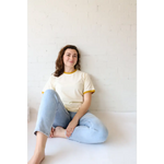 Woman in cream and gold ringer tee in organic cotton with polished prints and spandex means