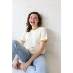 Woman in a Classic Women’s Ringer Tee in Mustard made from organic cotton with polished prints