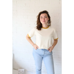 Woman wearing Classic Women’s Ringer Tee in Mustard made from organic cotton with polished prints