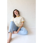 Woman in organic cotton Classic Women’s Ringer Tee in Mustard with polished prints and spandex means