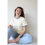 Smiling woman in Navy Classic Women’s Ringer Tee made of organic cotton with polished prints