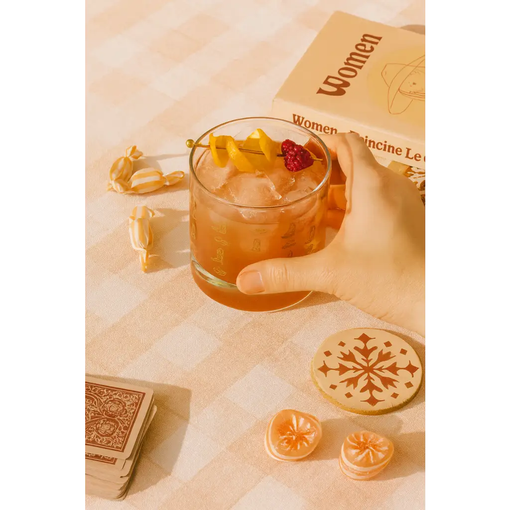 Iced cocktail in Cowboy Cocktail Glass with lemon peel and raspberry, perfect for peace signs camp vibes