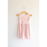 Pink Daisy Twirl Dress hanging on a wooden hanger with floral prints for a cute look