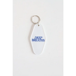 White oval keychain with DEEP BREATHS in blue, perfect for vintage hotel vibes