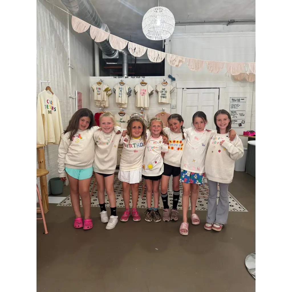 Group of happy girls at craft bar party with matching cream shirts, perfect for bar host events
