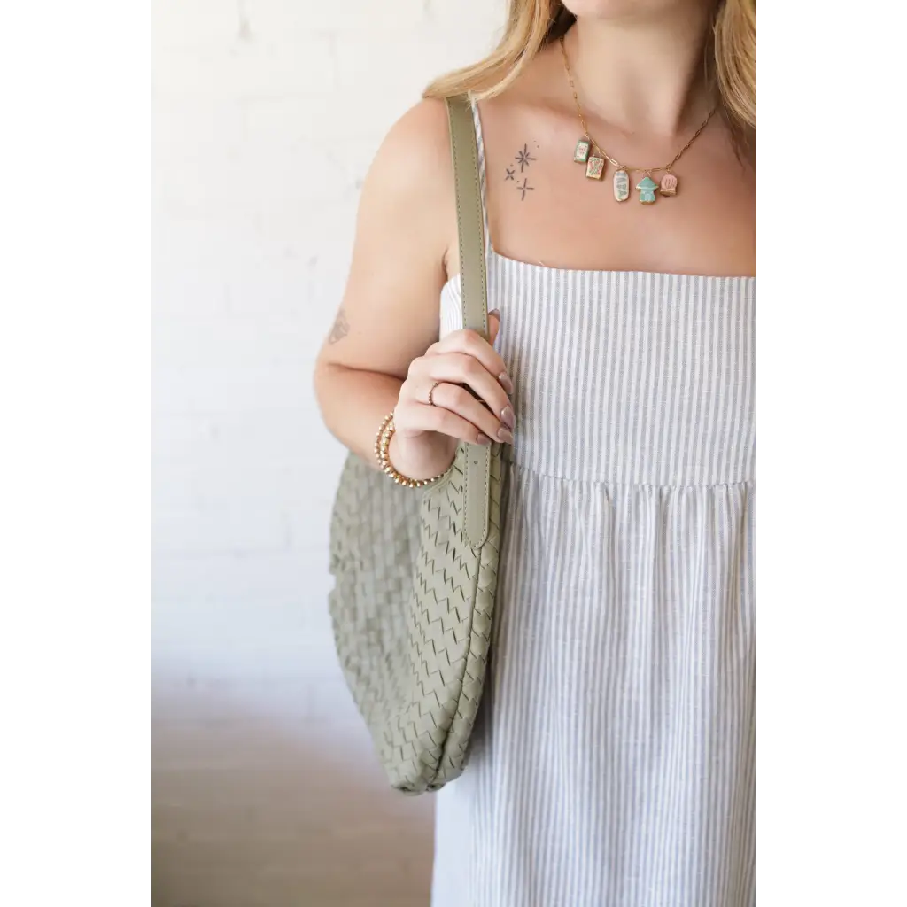 Woman in striped dress with Diana Woven Bag XL made of vegan leather, featuring two interior pockets