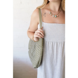 Woman in striped dress with Diana Woven Bag XL made of vegan leather, featuring two interior pockets