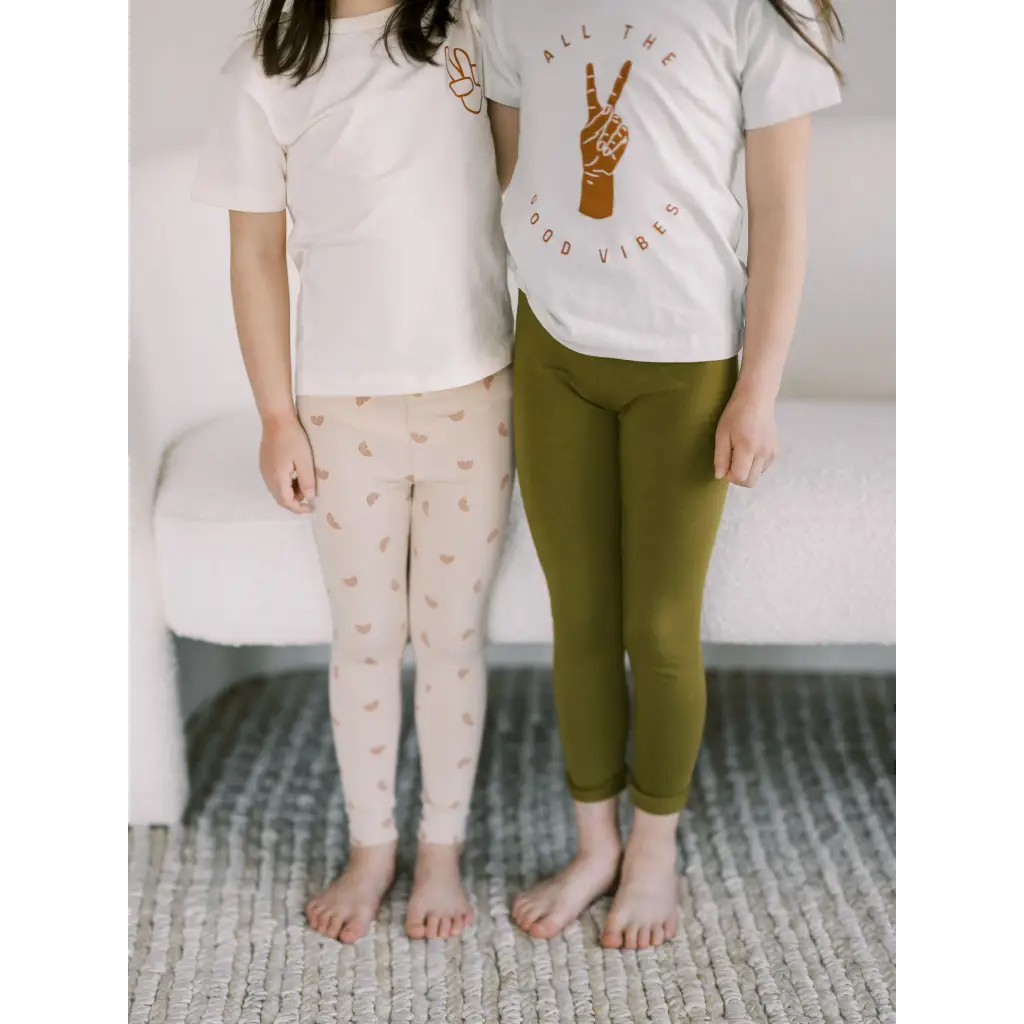 Two people in white t-shirts and Ditsy Rainbow Leggings by Polished Prints