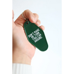 Green vintage hotel keychain tag with funny Don’t Make Me Look Around text