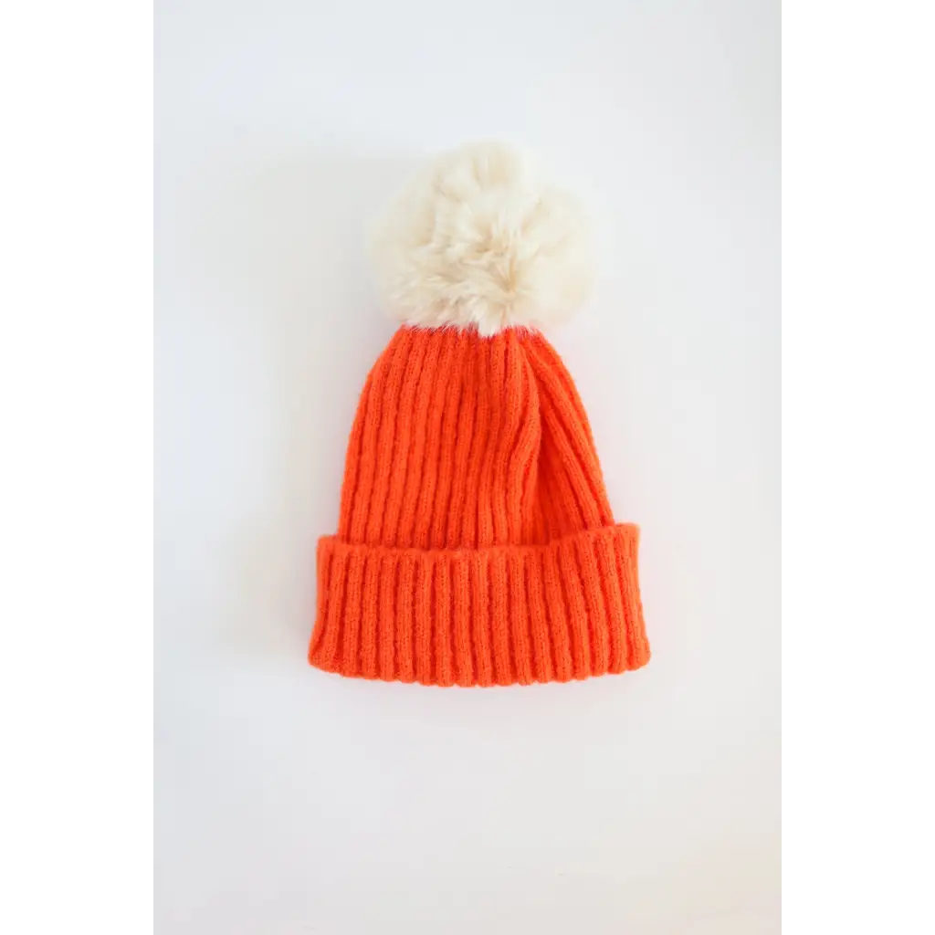 Orange knit Eloise Pom Pom Beanie for kids with a white pom-pom, perfect stylish winter accessory