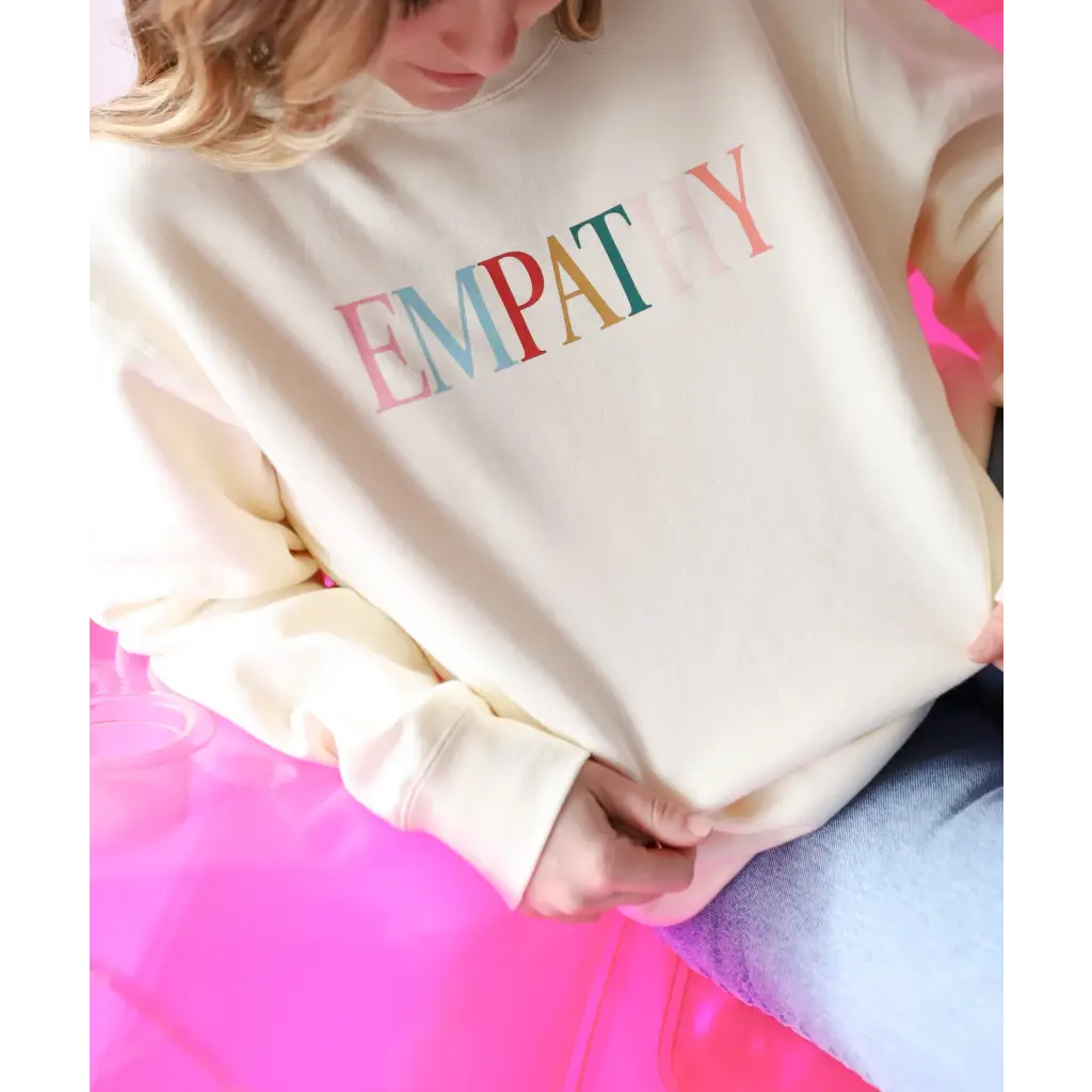 Cream-colored Empathy Midweight Crewneck Sweatshirt with colorful lettering design