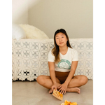 Person in Empowered Women Empower the World T-shirt by Polished Prints, holding orange snack