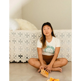 Person in Empowered Women Empower the World T-shirt by Polished Prints, holding orange snack